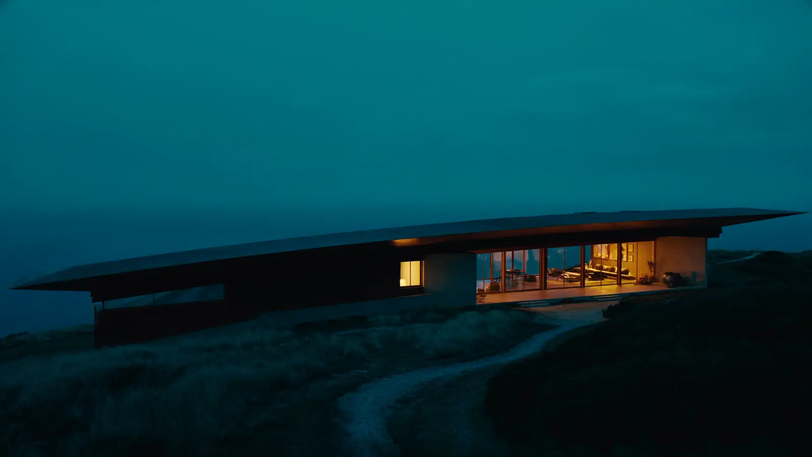 The pavilion lit up at night beside a winding path