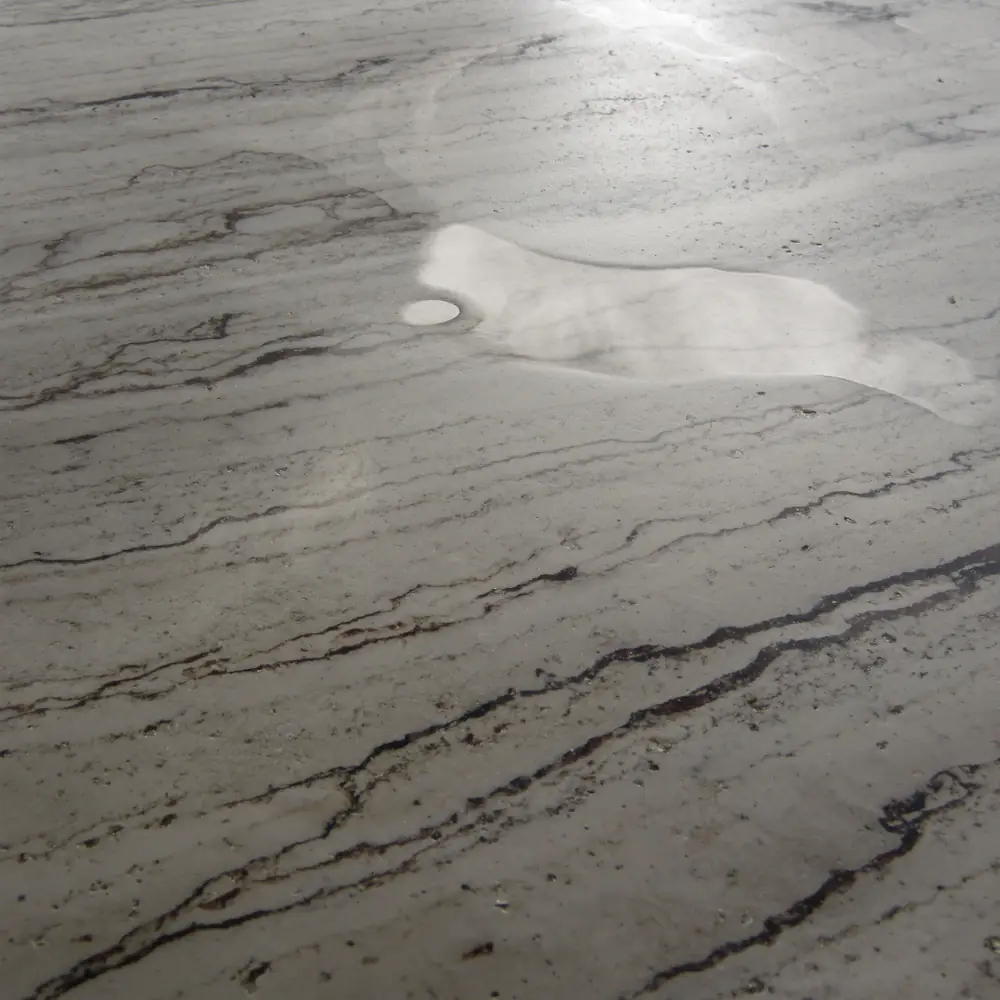 Honed travertine with a thin film of water reflecting the sky
